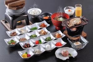 a table topped with dishes of food and a grill at Uminoniwa in Kamogawa