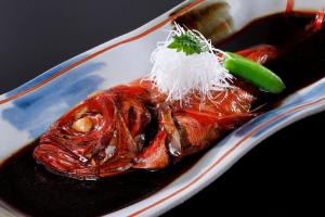 un plato de comida con un pescado con arroz en Uminoniwa, en Kamogawa