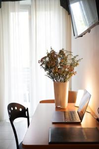 une table avec un ordinateur portable et une plante en pot dans l'établissement Hotel Sunset, à Rimini