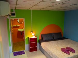 Cat Bungalow في كو لانتا: غرفة نوم بسرير وجدار أخضر