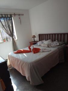 a bedroom with a bed with red sheets and a window at Hostel AGUS !!! in Guaymallen