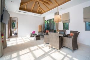 a living room with a table and chairs at Dalaa 9 in Kamala Beach