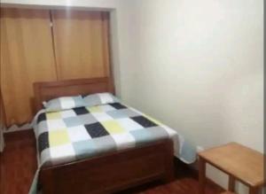 Dormitorio pequeño con cama y mesa en Hospedaje Sumita Wasi, en Puno