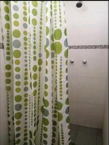 baño con cortinas de ducha verdes y blancas en Hospedaje Sumita Wasi, en Puno
