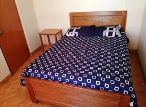 a bedroom with a bed with a blue and white comforter at Hospedaje Sumita Wasi in Puno