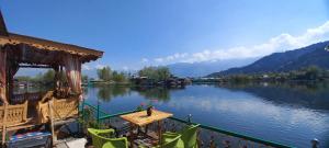 vistas a un lago con mesa y sillas en H B RAH Group Of Houseboats, en Durgjan