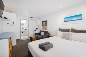 a bedroom with a large white bed and a living room at Moody's Motel in Blairgowrie