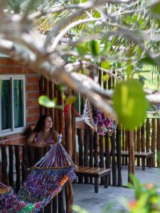 a woman sitting on a bench in front of a building at Cat Bungalow in Ko Lanta