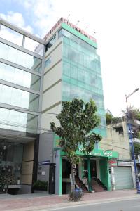 a building with a tree in front of it at Thành Vinh Hotel & Apartment in Ho Chi Minh City