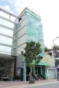 a building with a tree in front of it at Thành Vinh Hotel in Ho Chi Minh City