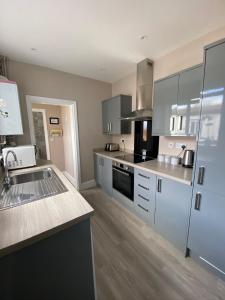 a kitchen with stainless steel appliances and white cabinets at Eclipse Apartment No 1 in Newmarket