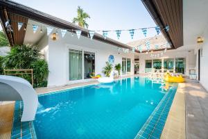 - une piscine avec toboggan dans une maison dans l'établissement Private Pool Villa•4BR•PATTAYA, à Ban Rong Po