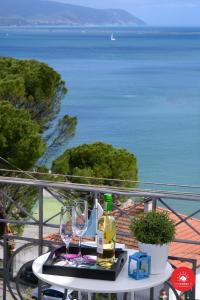 una mesa con 2 copas y botellas de vino en el balcón en Sea View Escape La Spezia - Cadimare, en La Spezia