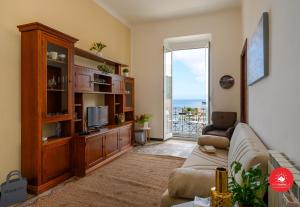sala de estar con sofá y TV en Sea View Escape La Spezia - Cadimare, en La Spezia
