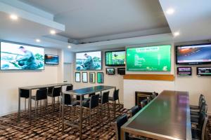 a bar with tables and chairs and televisions at Royal Hotel in Tumut