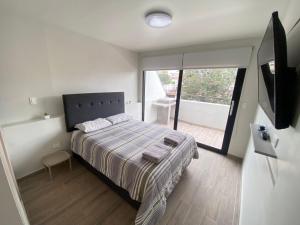 Un dormitorio con una cama y una ventana grande. en Deluxe Apartments in Arequipa Downtown, en Arequipa