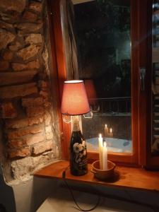 a lamp sitting on a table with two candles at Apartman i Sobe Čule Cres in Cres