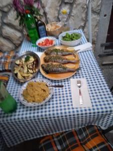 a blue and white checked table with food on it at Apartman i Sobe Čule Cres in Cres