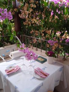 a table with a white table cloth and purple flowers at Apartman i Sobe Čule Cres in Cres