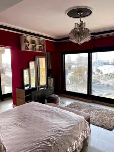 1 dormitorio con 1 cama grande y ventanas grandes en شقة فندقية بانوراما علي النيل, en El Cairo