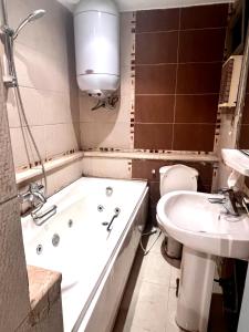 een badkamer met een bad, een toilet en een wastafel bij شقة فندقية بانوراما علي النيل in Caïro