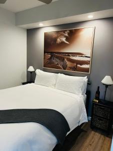 een slaapkamer met een wit bed en een schilderij aan de muur bij River cottage in Blairgowrie