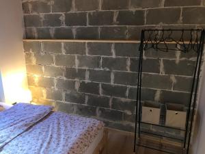 Stodoła في Postomino: غرفة نوم بحائط من الطوب وسرير