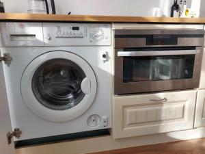 a washing machine and a microwave in a kitchen at Kesklinna peatuspaik in Tallinn