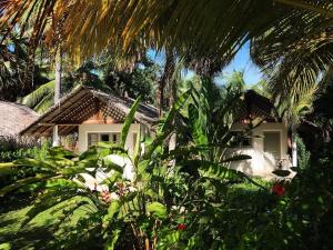 a house in the middle of a garden with trees at The Rascals Kite Resort in Kalpitiya