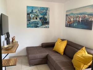 un soggiorno con divano marrone e un dipinto di Kuća za odmor Baya a Stara Baška