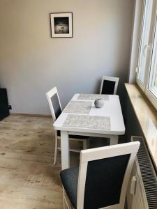 弗瓦迪斯瓦沃沃的住宿－Apartament Morski Relaks，用餐室内的白色桌椅