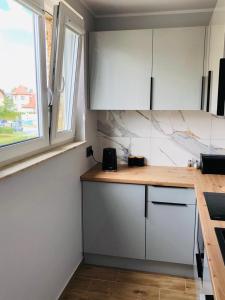 弗瓦迪斯瓦沃沃的住宿－Apartament Morski Relaks，厨房配有白色橱柜和木制台面