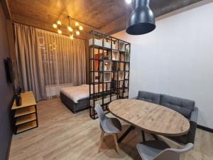 a living room with a table and a bed at Apart Hotel LOFT in Almaty