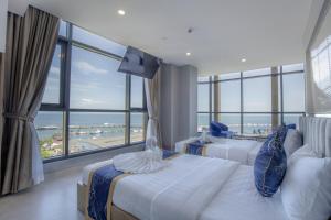a hotel room with two beds and a large window at Seascape Palace Hotel in Sihanoukville