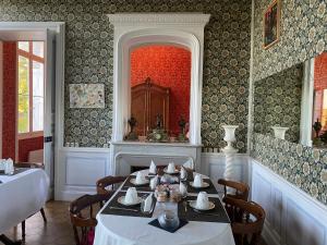 uma sala de jantar com uma mesa e uma lareira em Gîte 6 personnes 3 chambres château de la bouchatte em Chazemais