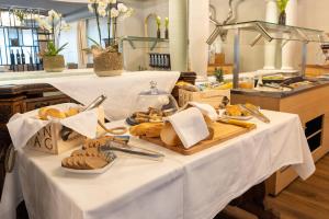 a table with bread and pastries on it at Adaastra Boutique Hotel in Naters