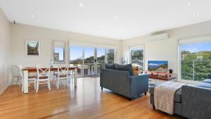 a living room with a table and a dining room at Mazza by the Sea in Lake Tyers