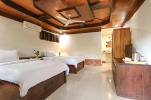 a bedroom with two beds and a ceiling at Artini 2 Cottage Ubud in Ubud