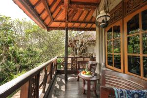 a porch with a table and a bowl of fruit on it at Artini 2 Cottage Ubud in Ubud