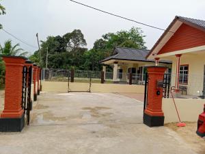 a row of orange pillars in front of a building at Homestay Adilah B in Pasir Puteh