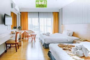 スラート・ターニーにあるCBD 2 Hotelのベッド2台とデスクが備わるホテルルームです。