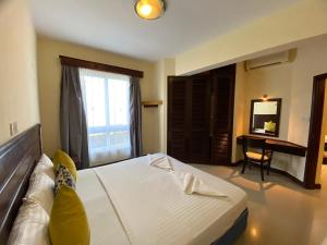 a bedroom with a bed and a desk in a room at Lux Suites Sunrise Apartments Nyali in Mombasa