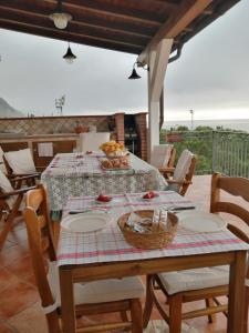 - une table avec des assiettes et une corbeille de fruits dans l'établissement Le Spiagge, à Letojanni