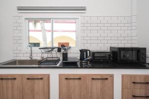 a kitchen counter with a sink and a microwave at 2BR Homey townhome 350M walk to Kata Beach Fully equipped in Kata Beach