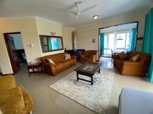 a living room with couches and a coffee table at Lux Suites Sunrise Apartments Nyali in Mombasa