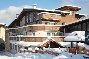 een gebouw bedekt met sneeuw en met sneeuw bedekte daken bij Apartment in Wildschönau with a balcony or terrace in Niederau