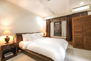 a bedroom with a white bed and a window at Artini 2 Cottage Ubud in Ubud +18 photos