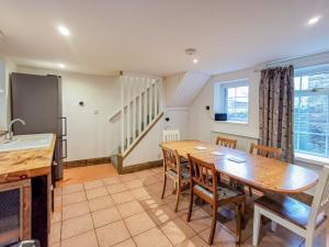 a kitchen and dining room with a wooden table and chairs at Daffodils in Coanwood