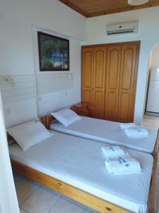 um quarto com duas camas e uma televisão na parede em VILLA AGIA AIKATERINI em Amoudi