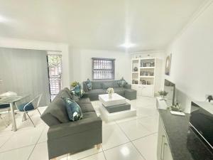 a living room with a couch and a table at Stunning 2 Bed - Rooftop Braai Area - Sunset Views in Durban